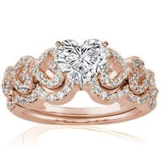 a heart shaped diamond ring with two rows of diamonds on the band, set in 18k rose gold