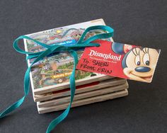 a stack of books with a tag tied to it that says disneyland on the front