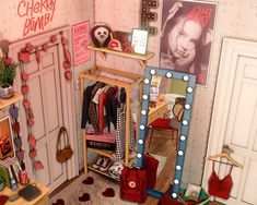 a doll house with clothes and accessories on the shelves in front of it, including a mirror that says cherry bomb