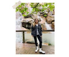 a woman standing in front of a waterfall