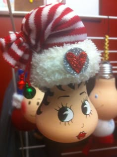 three christmas ornaments hanging from the ceiling in front of a red and white striped wall