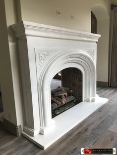 a white fireplace in a living room with hardwood floors