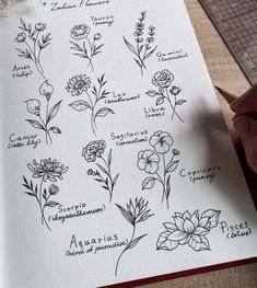 a hand is holding a pen over a paper with flowers and plants drawn on it