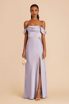 a woman wearing a lavender colored dress with an off the shoulder neckline and thigh slit