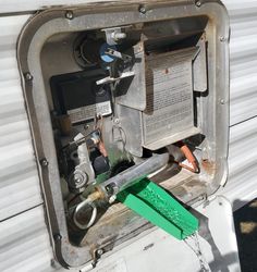 an electrical box that is attached to the side of a white trailer with green handles