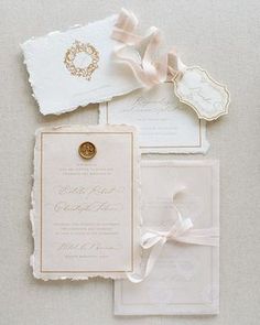 the wedding stationery is laid out on top of each other with ribbons and tags