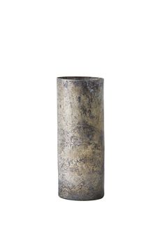 a tall metal vase sitting on top of a white wall