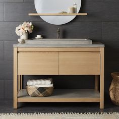 a bathroom vanity with a round mirror above it