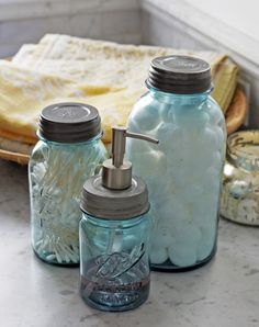 three mason jars with soap dispensers sitting on a counter