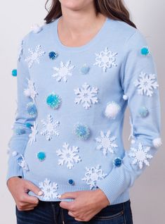 a woman wearing a blue sweater with snowflakes on it