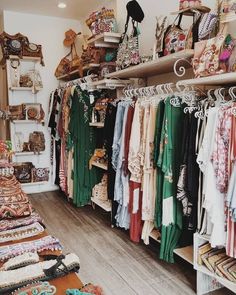 a clothing store filled with lots of different types of clothes and purses on shelves