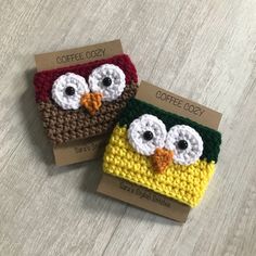 two crocheted coffee cozies sitting on top of a wooden table