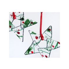 three glass ornaments hanging from a red ribbon