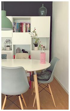 a dining room table with chairs and bookshelf in the backround area