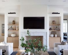 a living room filled with furniture and a flat screen tv mounted on the wall above a fireplace