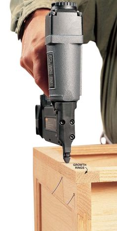 a man is using a drill to fix a piece of wood with a power tool