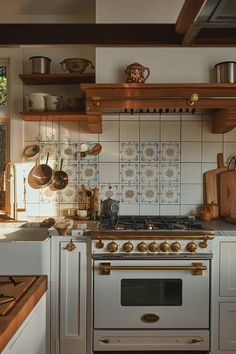 a stove top oven sitting inside of a kitchen next to a counter with pots and pans on it