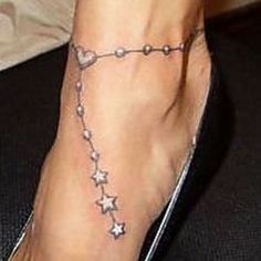 a woman's foot with stars on it and a chain attached to the ankle