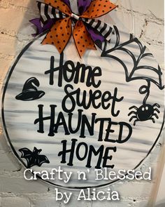 a sign that says home sweet, haunted home with bats and spider webs on it