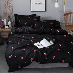 a bed with black comforter and pillows in a room next to a white lamp