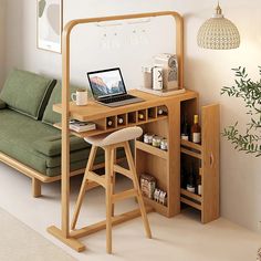 a laptop computer sitting on top of a wooden desk next to a green couch in a living room