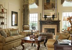 a living room filled with furniture and a fire place in front of a mirror on the wall