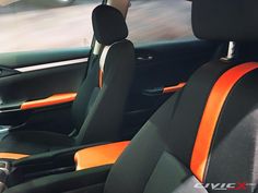 the interior of a car with black and orange seats