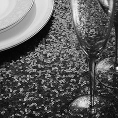 two wine glasses sitting on top of a table next to plates and utensils