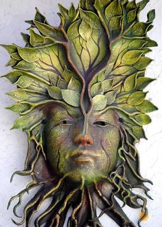 a green man's face with trees growing out of the head and roots on it