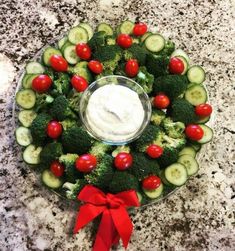 a platter with cucumbers, tomatoes and other veggies on it