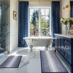 a bathroom with blue and white decor, including a claw foot tub in the center