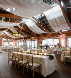 a banquet hall with tables and chairs covered in white draping