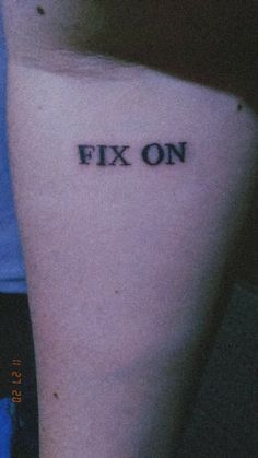 a person with a tattoo that says fix on