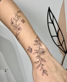 a woman's arm with flowers and leaves tattooed on the left side of her arm