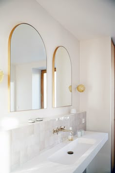 a bathroom sink with two mirrors above it