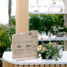 a table with flowers and a sign on it