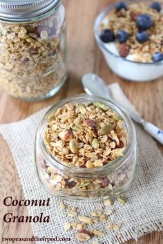 two glass jars filled with granola on top of a wooden table