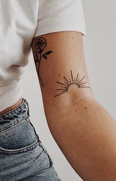 a woman's arm with a tattoo on it that has a sun and flowers