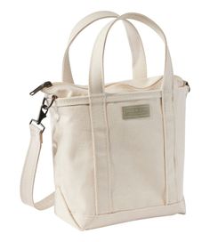 a white bag with handles and straps on the front, it has a zippered closure