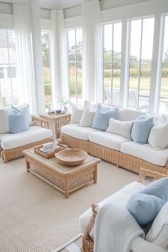 a living room filled with lots of furniture next to large window covered in white curtains