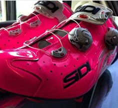 a pair of pink shoes sitting on top of a car