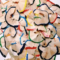 a pile of paper flowers on top of a white table