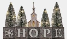 a wooden sign that says hope with trees and a church in the background