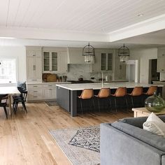 a large open kitchen and living room with hardwood floors