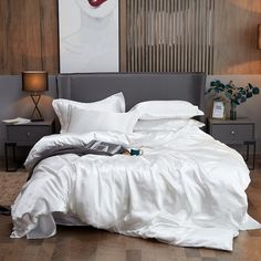 a bed with white sheets and pillows in a room