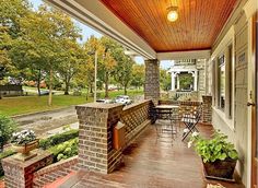 an outdoor covered porch with tables and chairs