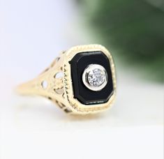 Beautifully-detailed gold onyx diamond ring. Chunky Old European Cut diamond bezel set in 18k white gold. The rest of the ring is fashioned from 14k gold. Fabulous filigree gallery and shoulders. The ring is a warm white gold. Meaning, I believe it is white gold alloy that has yellowed over time. It could also be a purposeful very light yellow gold. Size 3.75 - 4 *Diamond: 2.7mm 0.07ct SI1-I2 G-H Onyx: 7.24 mm x 5.64 mm Weight: 2.1g Very good antique condition. No breaks in the filigree. Stones Elegant Jewelry With Rose Cut Round Diamonds, Black Bezel Set Jewelry For Anniversary, Luxury Onyx Jewelry For Weddings, Elegant Diamond Ring With Bezel Setting And Round Stone, Elegant Diamond Ring With Bezel Setting, Exquisite Bezel Set Jewelry For Anniversary, Exquisite Jewelry With Bezel Setting For Anniversary, Elegant Onyx Diamond Ring Gift, Elegant Onyx Diamond Ring As Gift