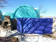 an outdoor fireplace in front of a blue wall