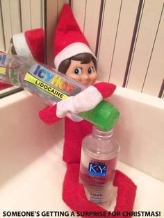 an elf is holding a bottle of toothpaste in his hand and sitting on the edge of a bathroom sink