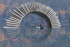 a person in a kayak floating on top of a body of water next to trees